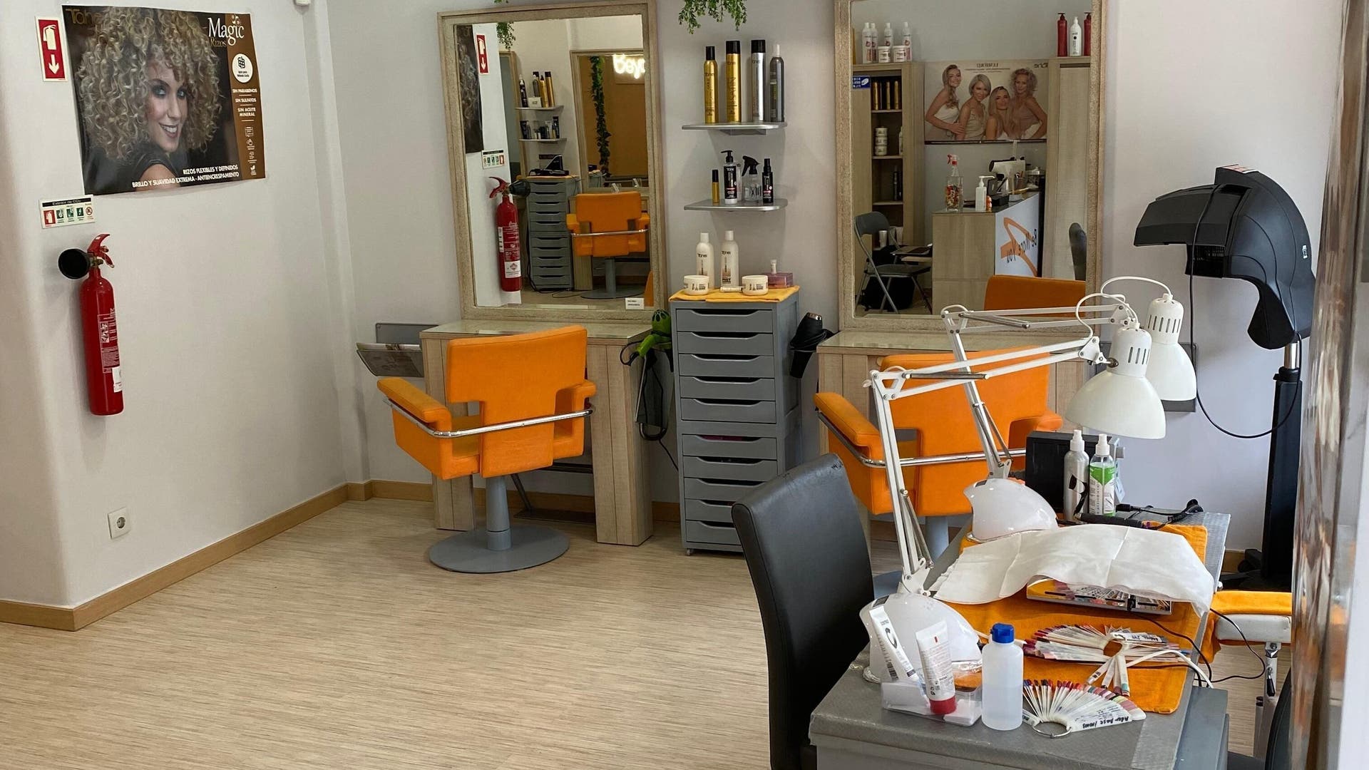 Interior moderno do salão Be More You em Linda-a-Velha, Lisboa, PT, com cadeiras laranja vibrantes.