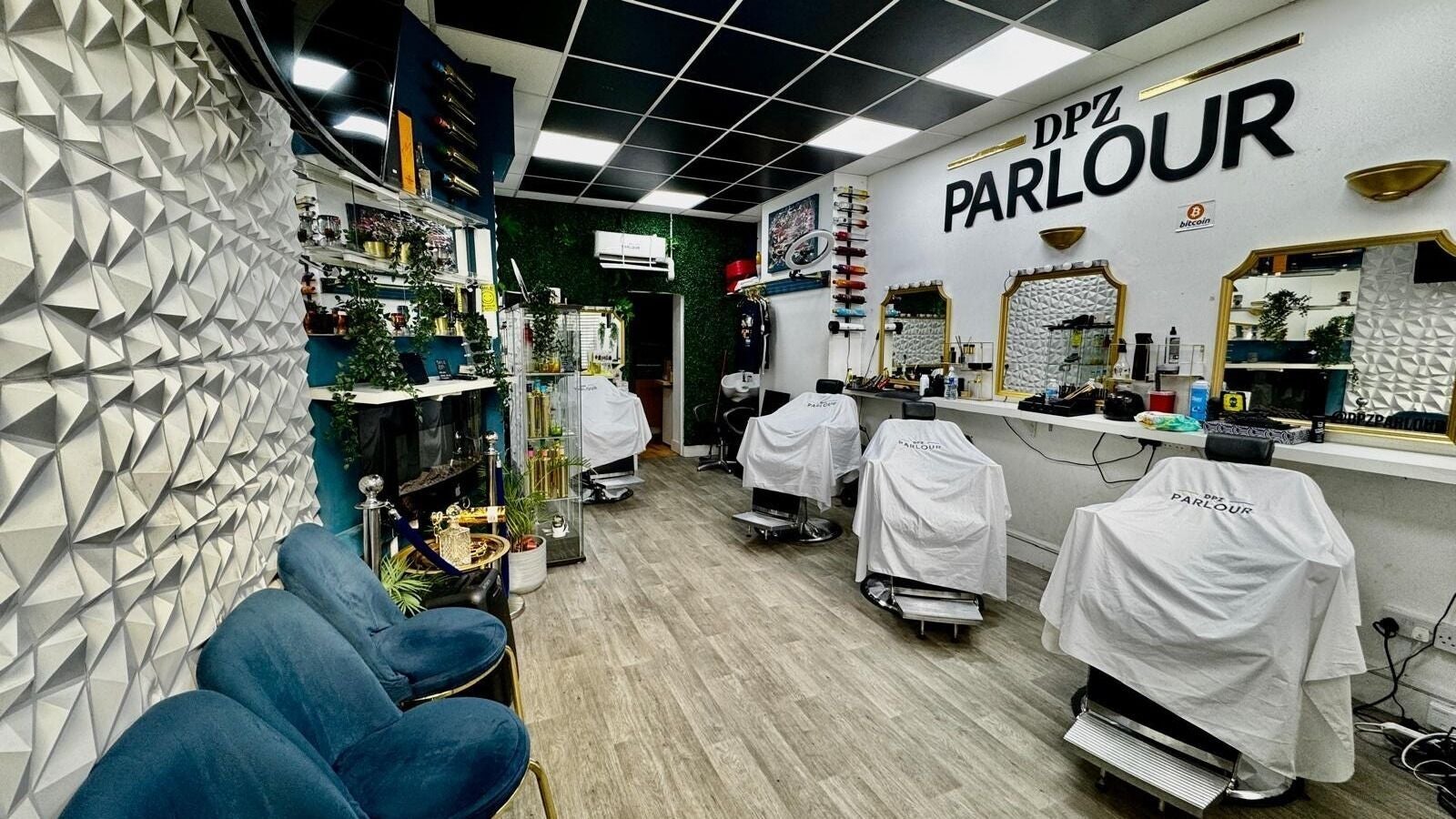 Stylish interior of Dpz Parlour in Gravesend, England, GB featuring plush seating and sleek barber stations.