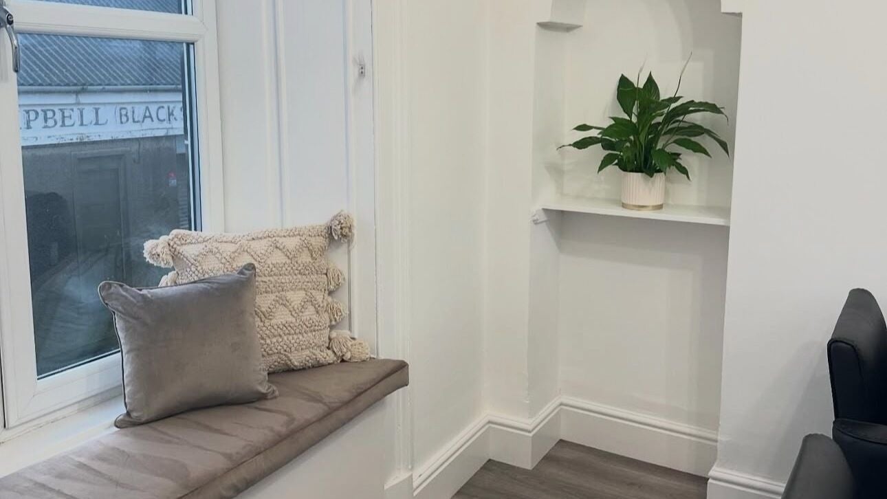 Inviting seating area with cushions at Hair I Am by Hazel Watson, Hamilton, Scotland, GB.