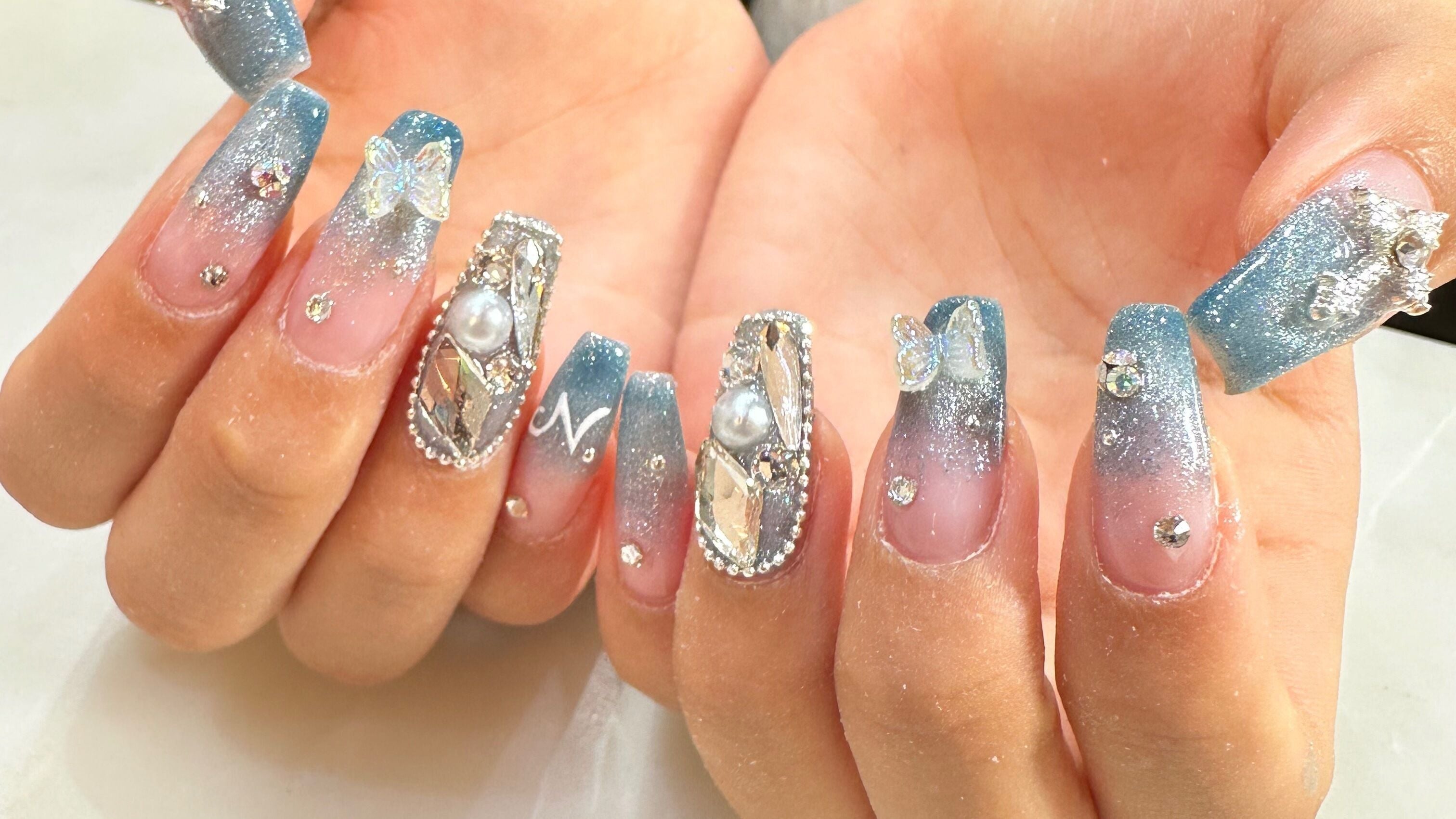 Elegant blue nails with rhinestones at Bon Nail & Spa, Auckland, Auckland, NZ. Perfect for a glamourous look.