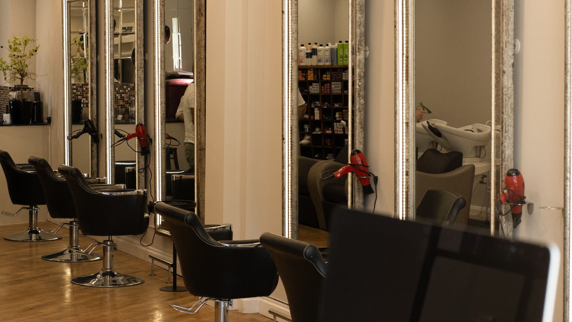 Interior of TOQQA Hair Salon in London, England, GB featuring stylish mirrors and salon chairs.
