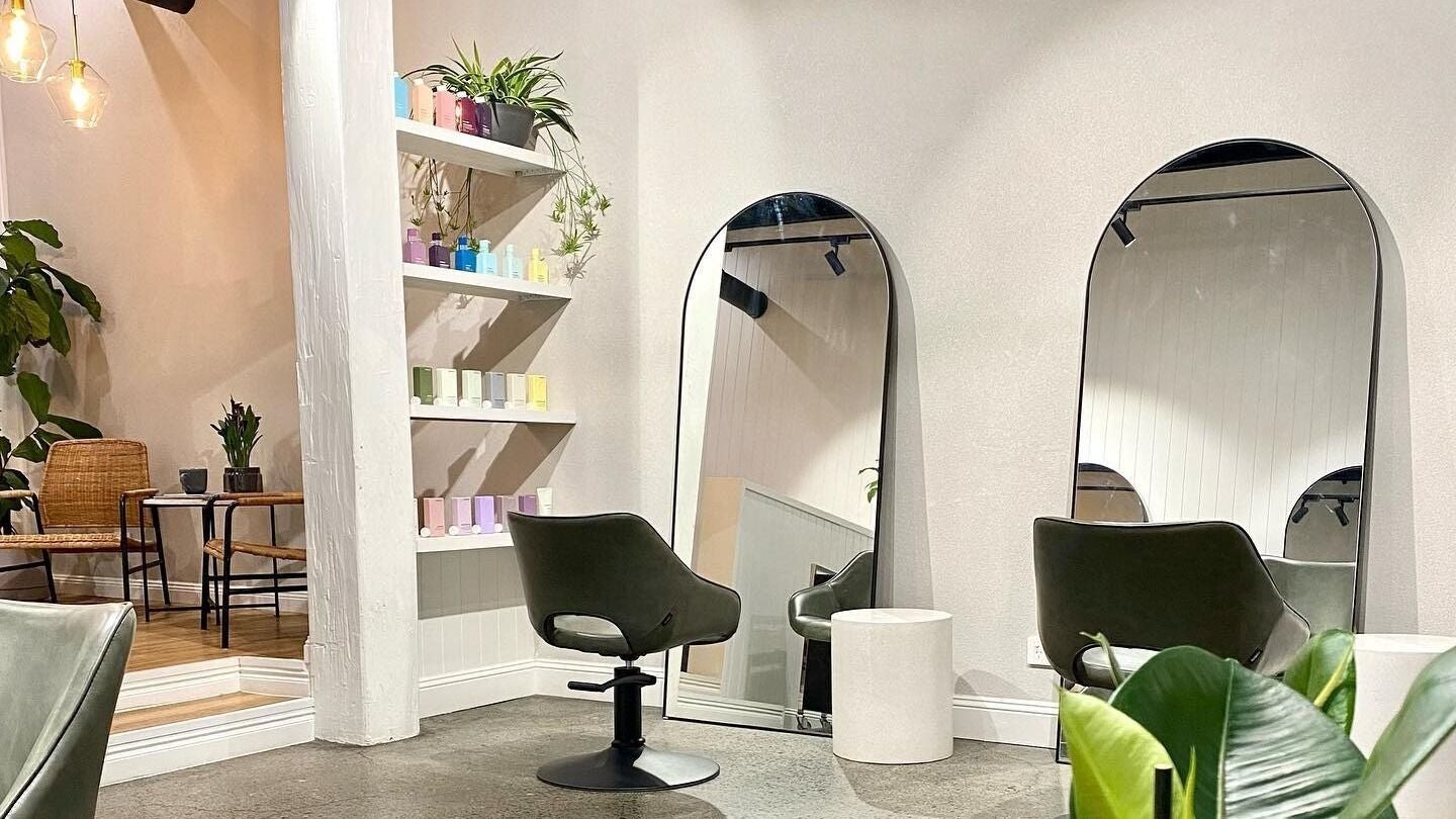 Elegant styling area at Alfie Hair Design in Teneriffe, Queensland, AU with mirrors and modern chairs.