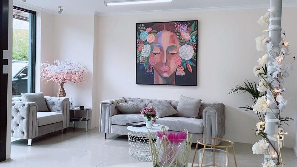 Stylish waiting area at Galaxy Lashes, Melbourne, Victoria, AU with chic sofas and vibrant artwork.