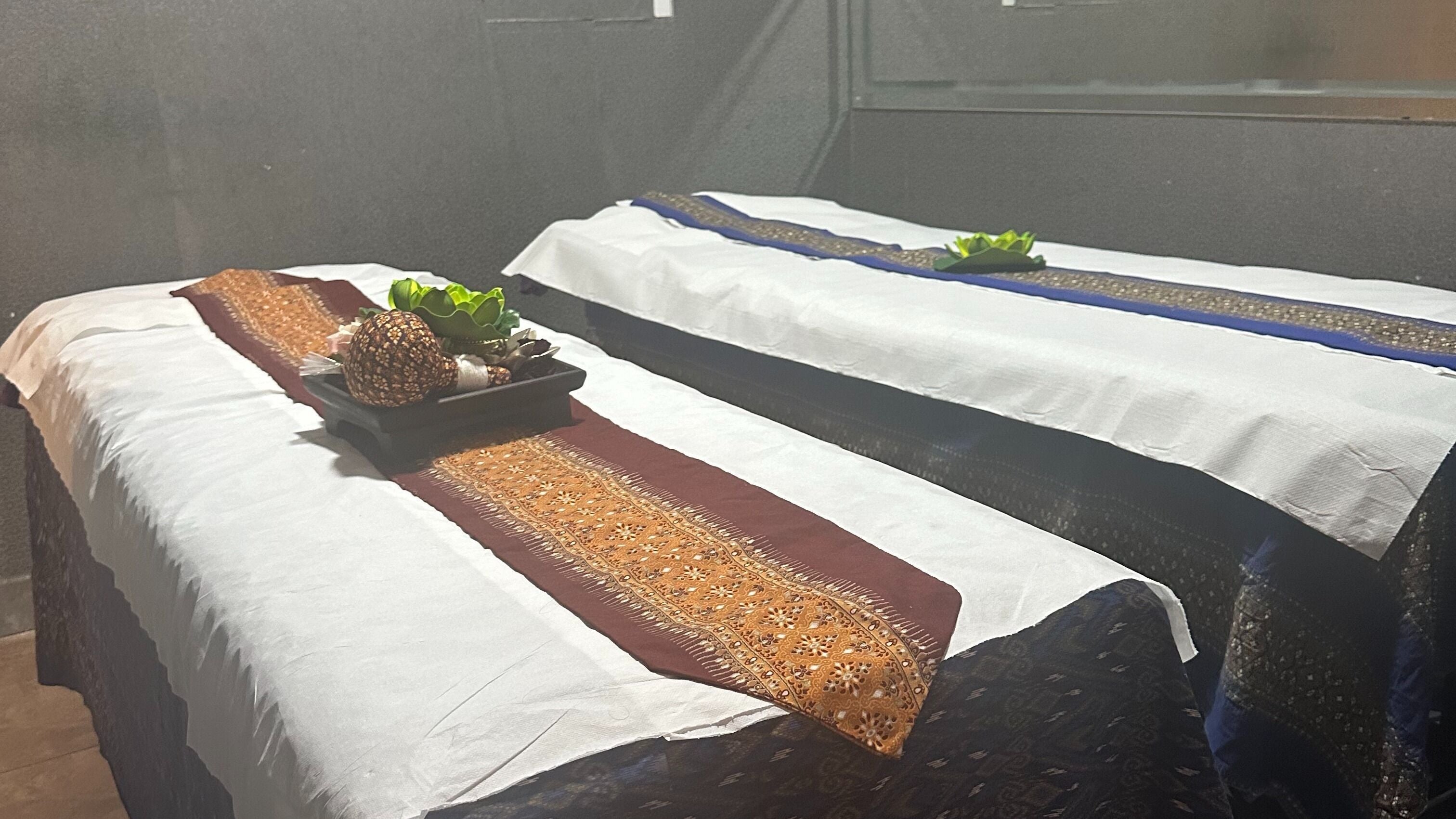 Massage tables at Central Thai Massage & Spa, London, England, GB, elegantly prepared with traditional decor.