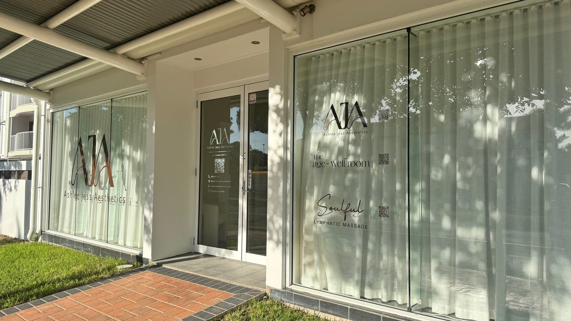 Front view of The Age Well Room in Maroochydore, Queensland, AU, with elegant glass doors and lush surroundings.