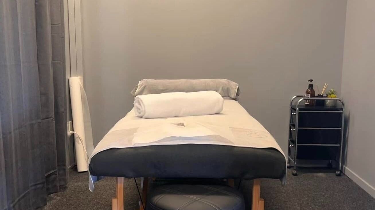 Calming massage room at Jm's Beauty, Auckland, Auckland, NZ, featuring a neatly made bed and soothing decor.