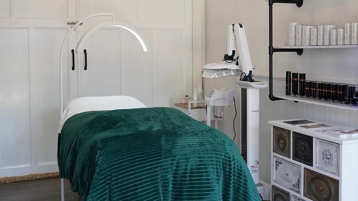 Serene treatment room at Skin Wellness Clinic, HIGETT, Victoria, AU, featuring a plush green bed and sleek equipment.