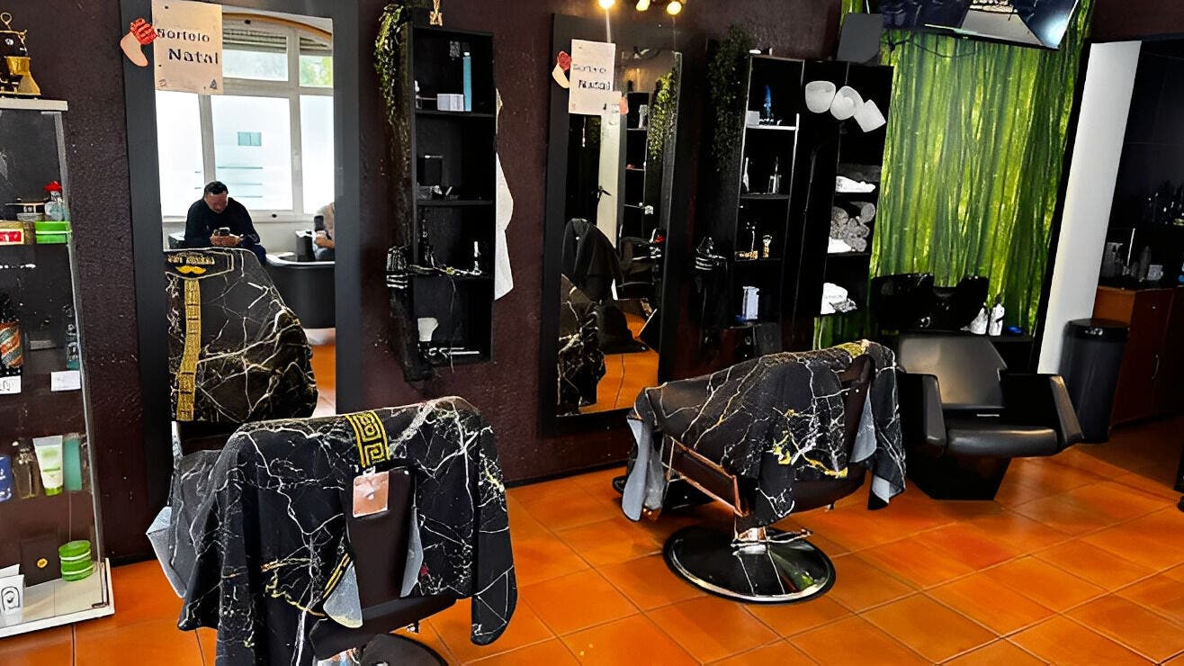 Interior moderno do JB STUDIO CAPILAR (AGENDAMENTOS) em Alcabideche, Lisboa, PT, com cadeiras elegantes e espelhos.