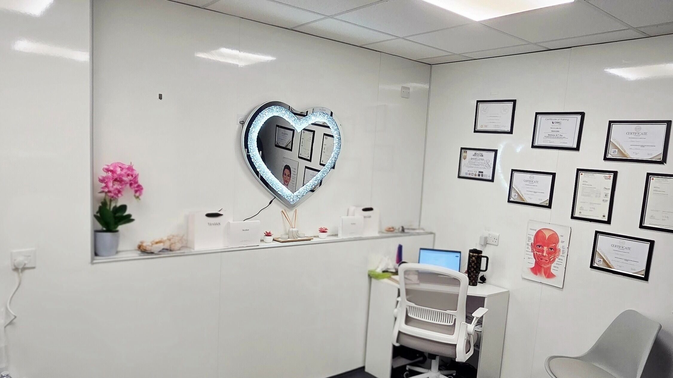 Elegant office at GCI Advanced Aesthetics, Aberdeen, Scotland, GB with heart-shaped mirror and certifications.