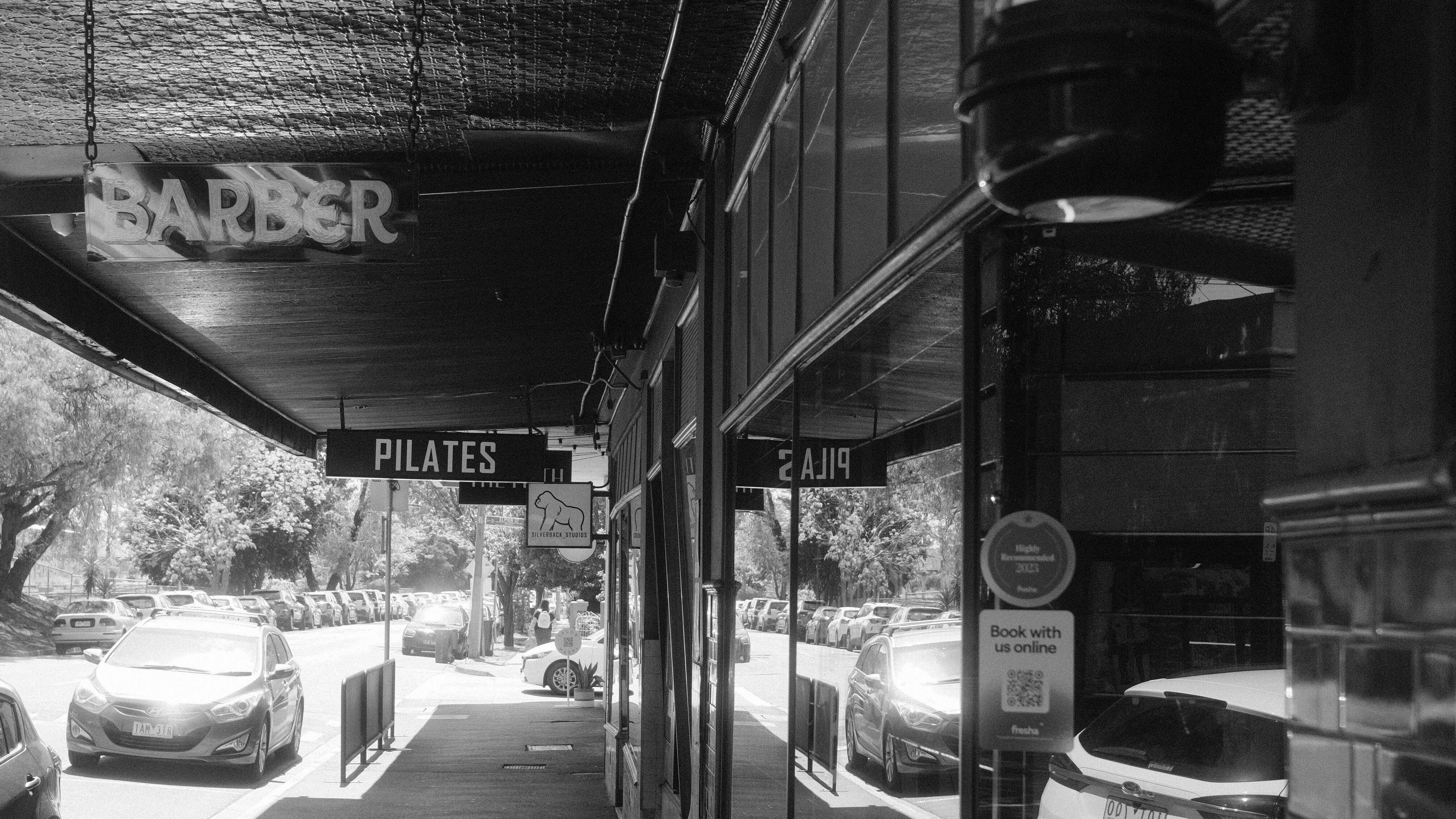 Street view with Lighthouse Barbers in Melbourne, Victoria, AU, offering a welcoming entrance.