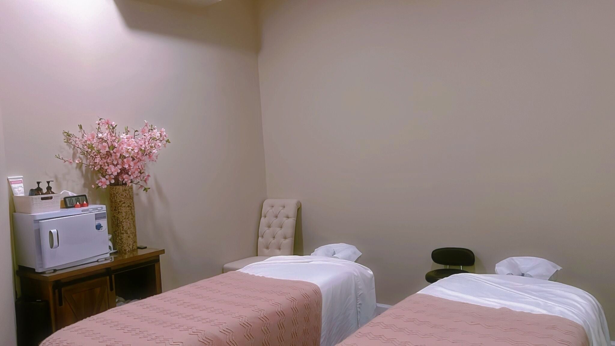 Relaxing treatment room at BeYoung Total Wellness Spa in Tysons, Virginia, US with two massage tables.