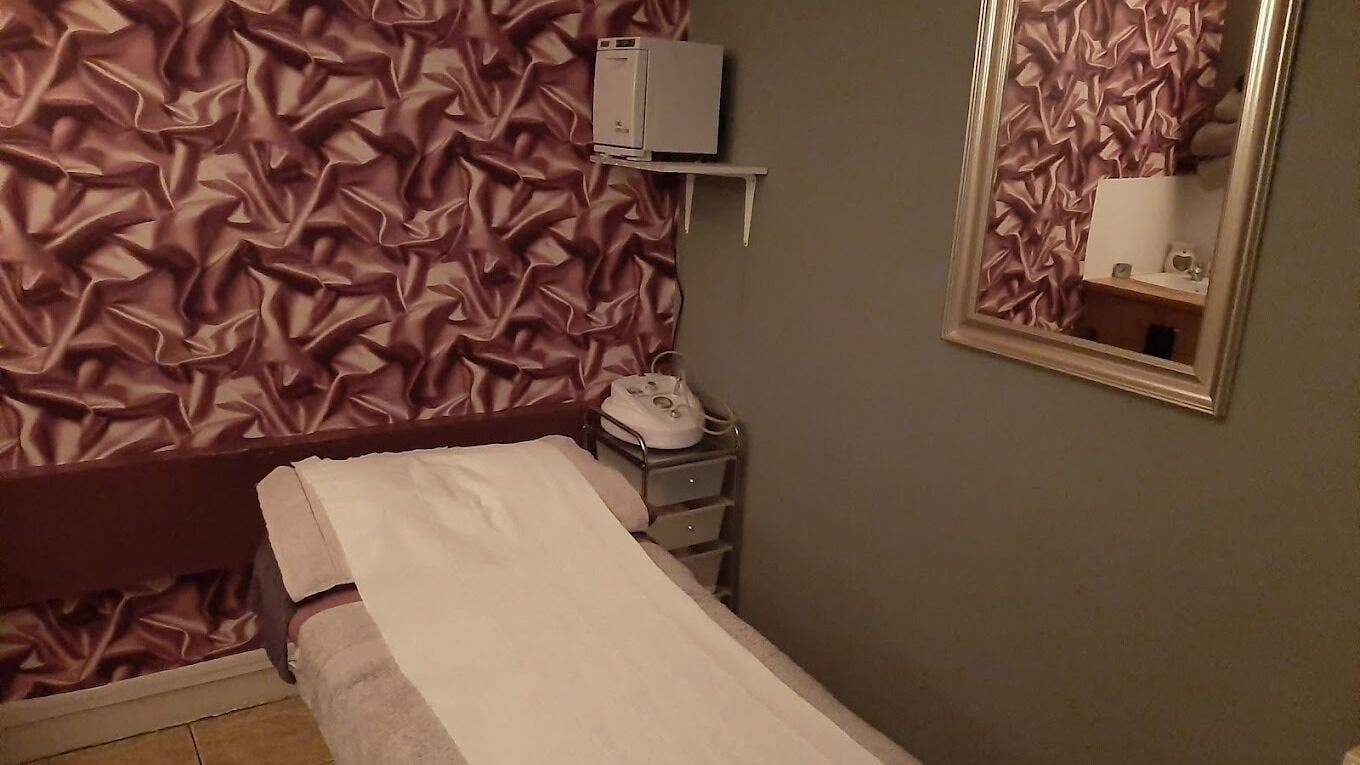 Luxurious treatment room at Lumiere Beauty Clinic in Glasgow, Scotland, GB with rich decor and massage bed.