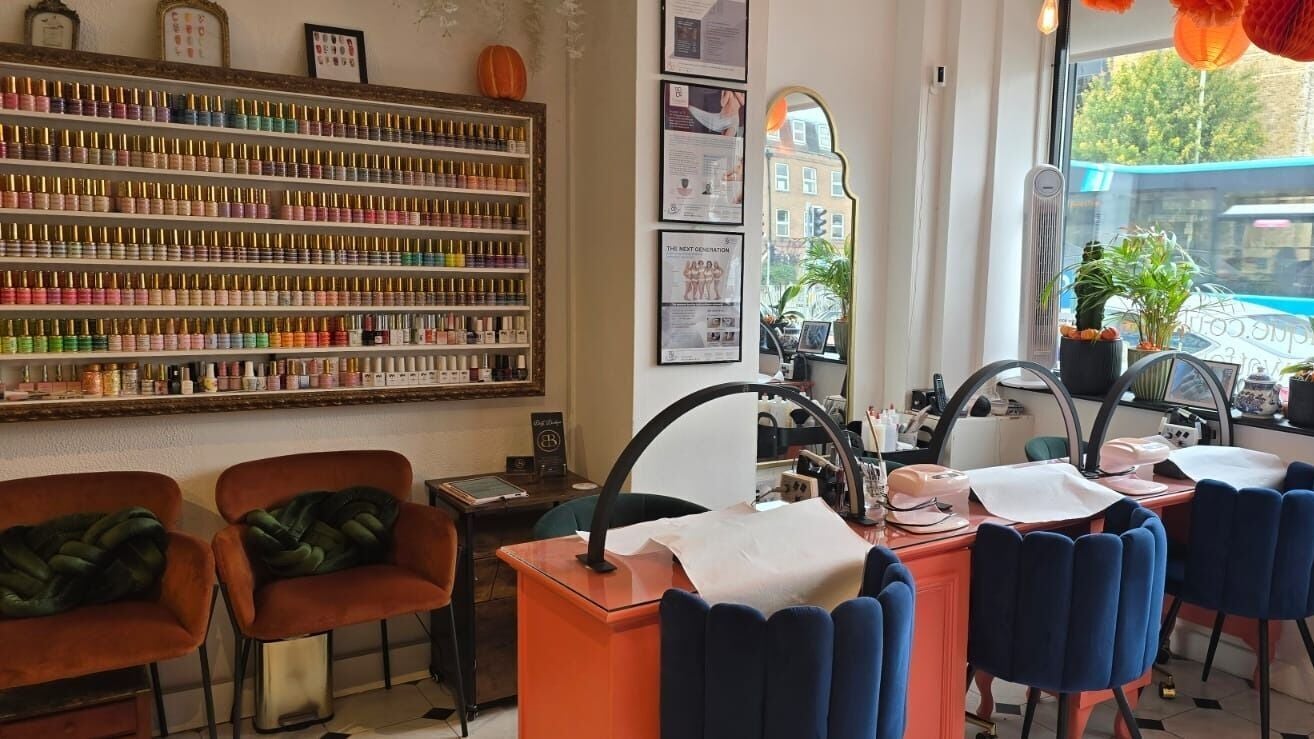 Elegant nail salon setup at Body Boutique, Watford, England, GB, featuring vibrant polish display and plush seating.