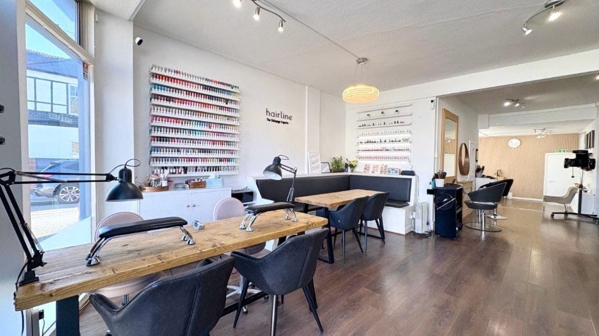 Stylish interior of Hairline - Southfields, Southfields, United Kingdom, GB with nail polish displays and seating.