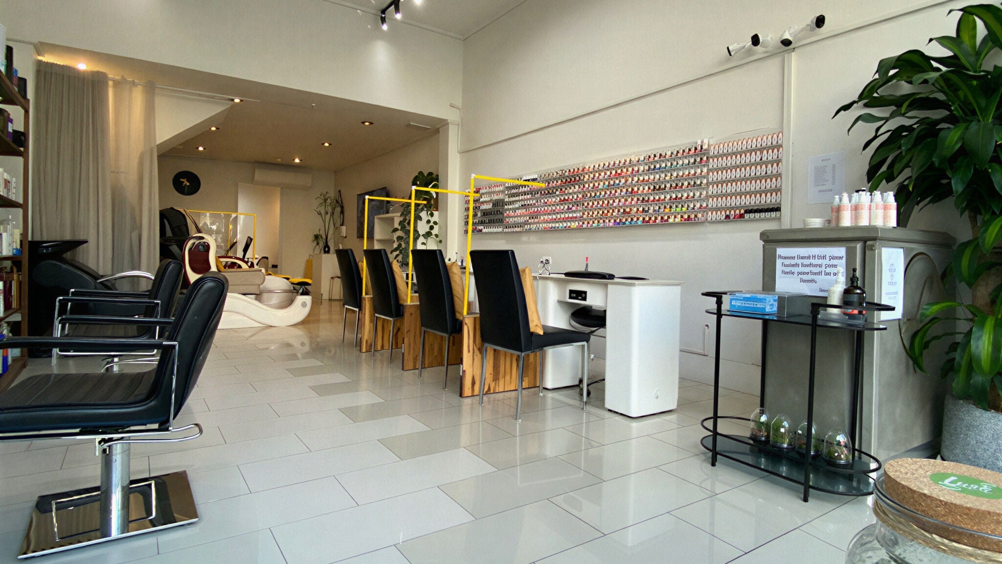 Modern interior of Luminous Hair Nail Spa in Melbourne, Victoria, AU showcasing sleek chairs and nail polish wall.