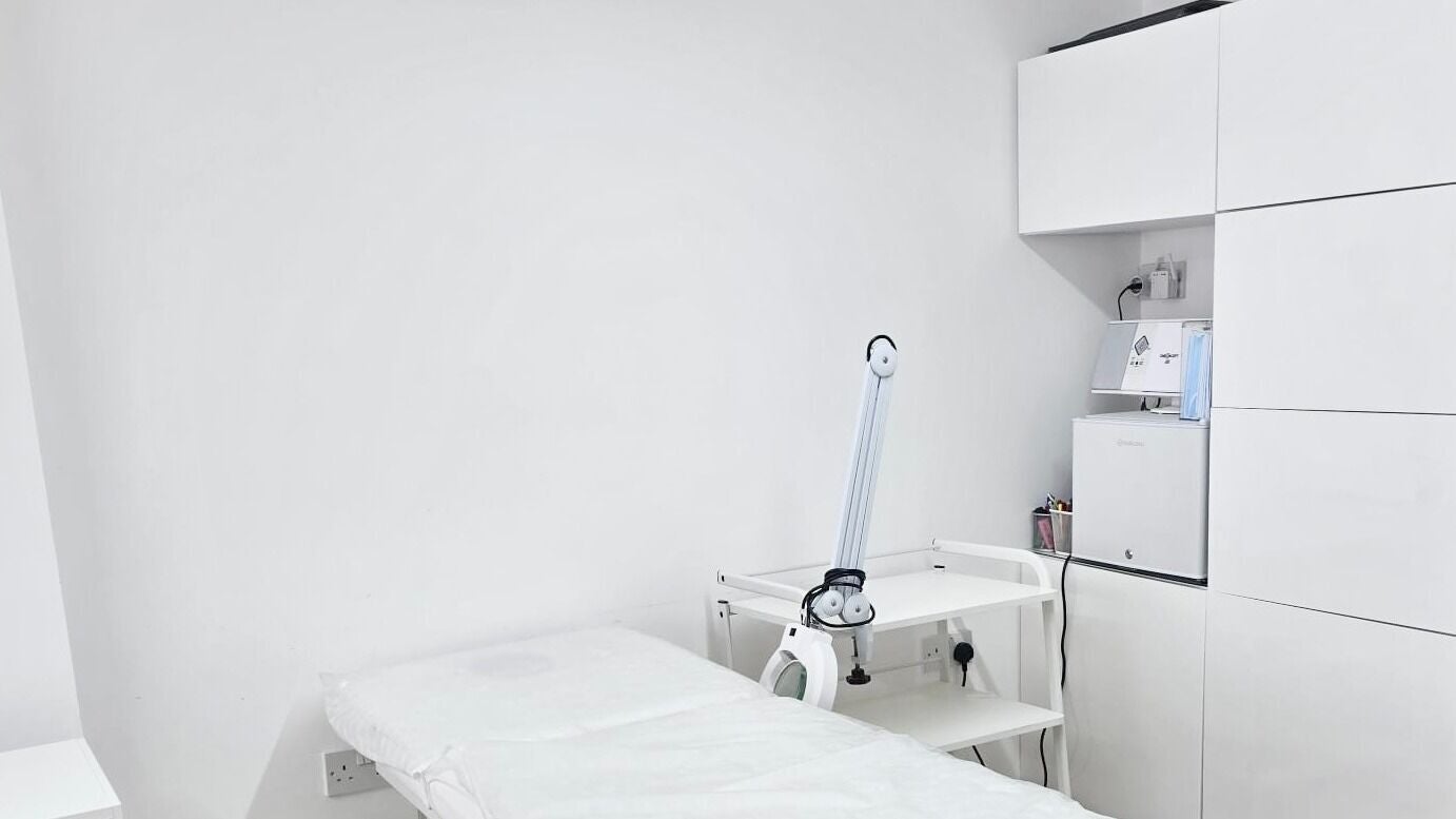 Clean, minimal treatment room at Riana Aesthetics - Luton, Luton, England, GB. Features a treatment bed and equipment.