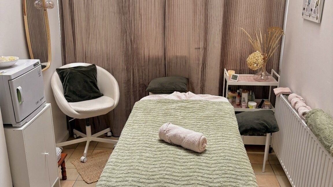 Cabine de soin relaxante chez Manabru, Etterbeek, Bruxelles, BE, avec table de massage et chaise confortable.