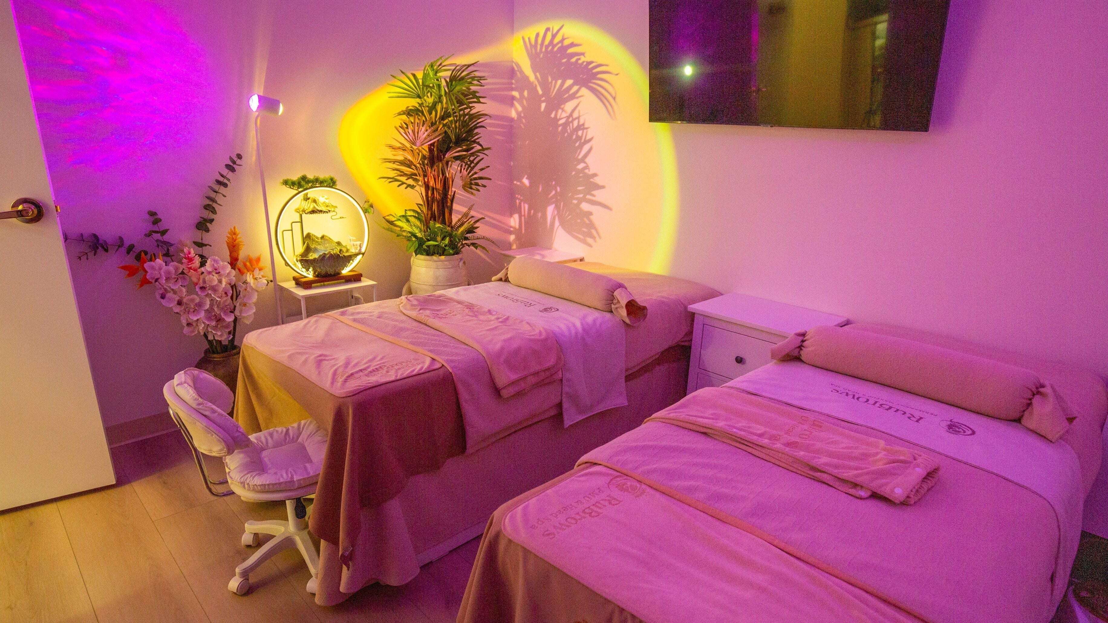 Relaxing massage room at RuBrows PMU & Head Spa in Cincinnati, Ohio, US, featuring cozy beds and ambient lighting.