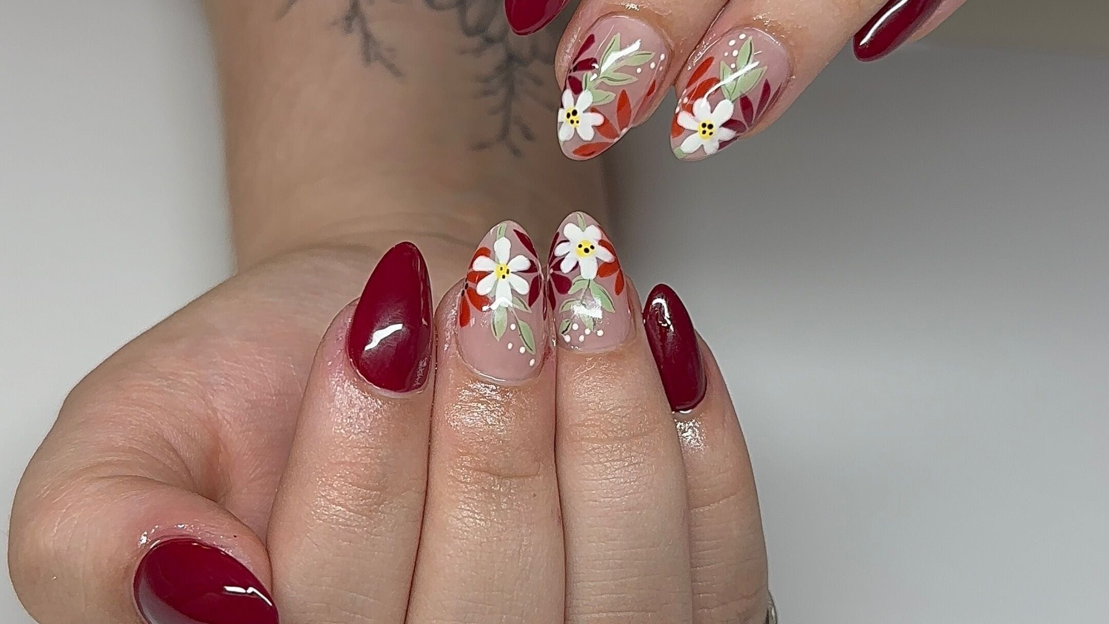 Stylish floral nail art in vibrant red at Good Vibes Nail Salon, Grand Rapids, Michigan, US.