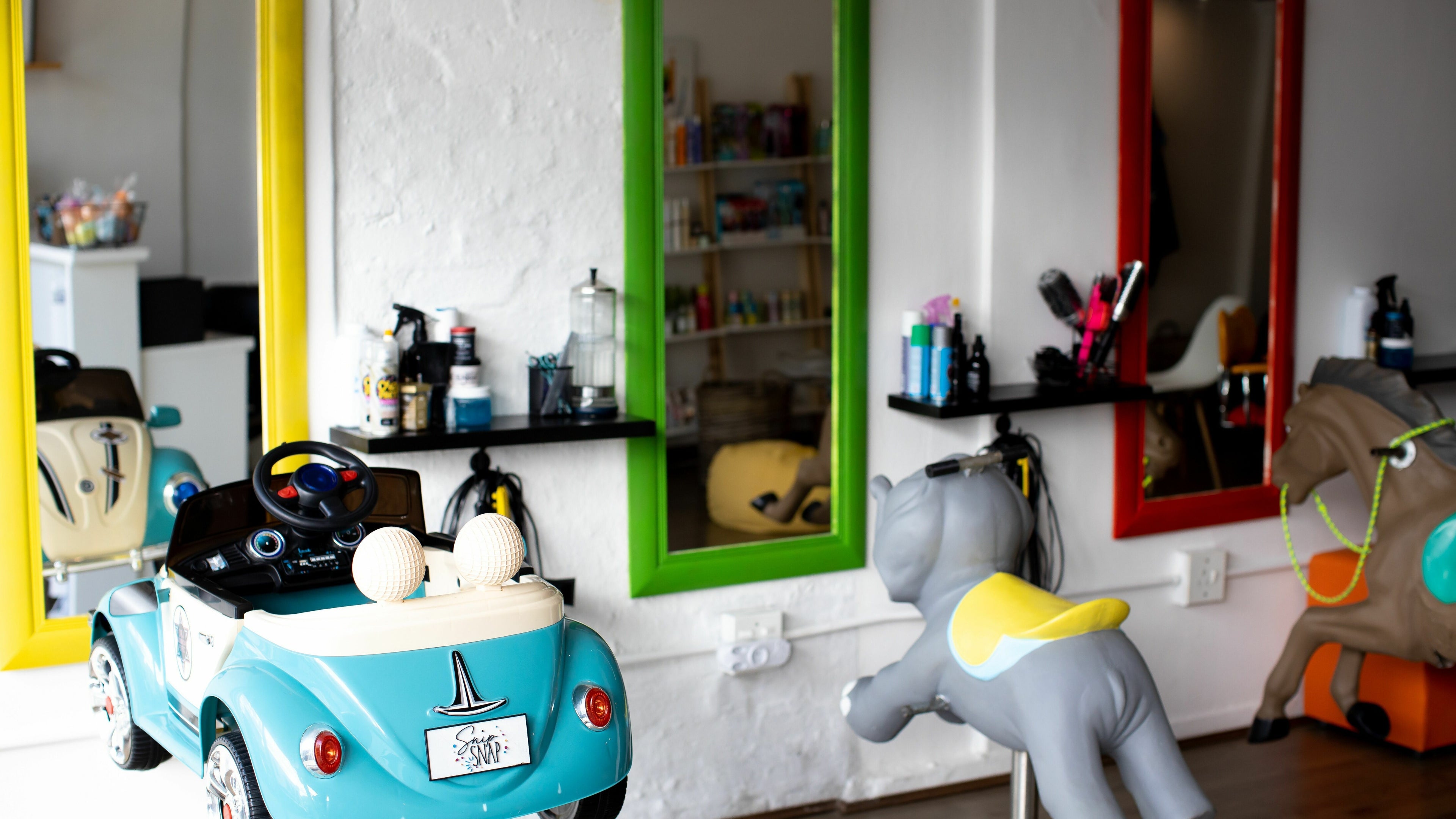 Child-friendly salon with toy cars and mirrors at Snip Snap, Newlands, Cape Town, Western Cape, ZA.