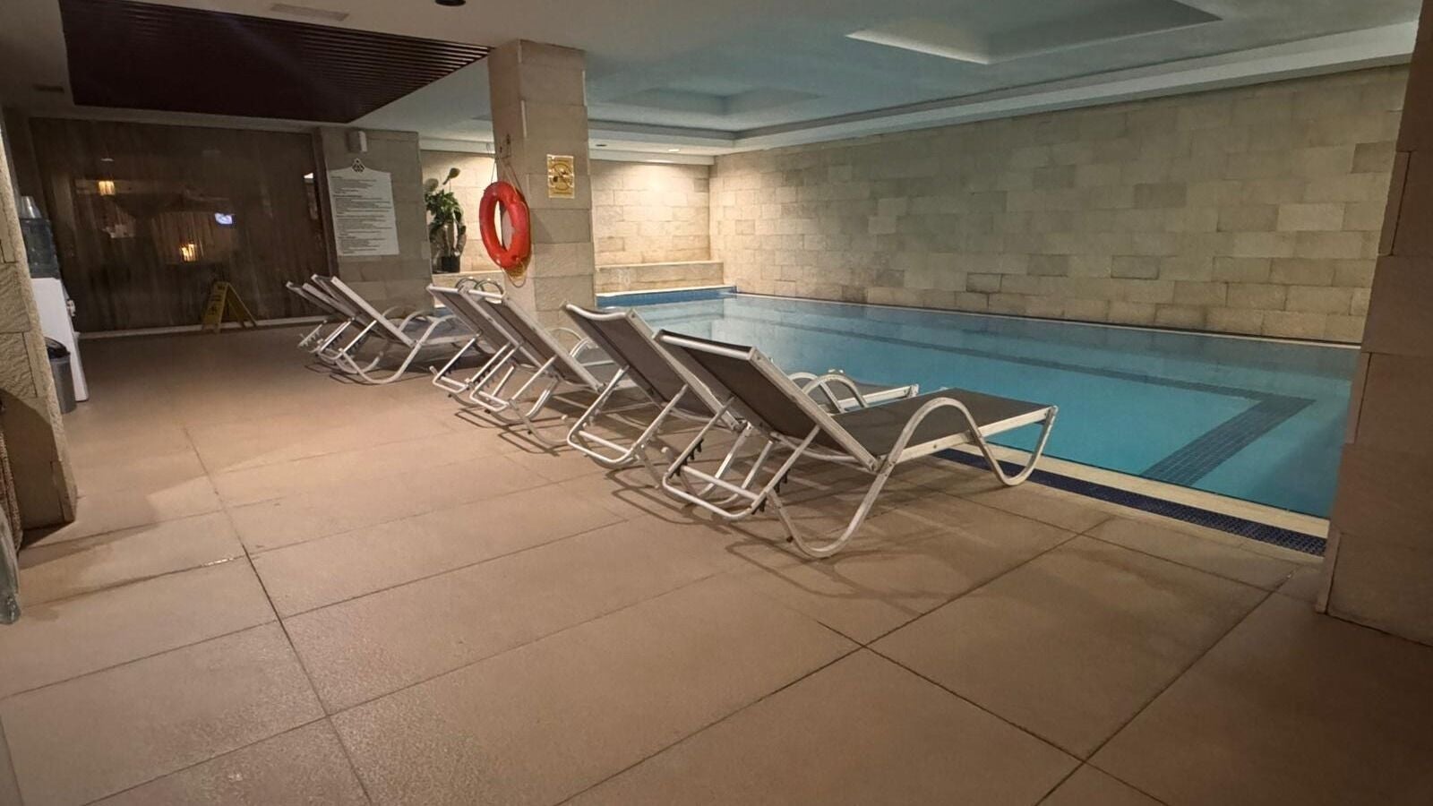 Indoor pool at Artemis Spa in Emre Hotel, Muğla, TR, featuring lounge chairs and elegant design.