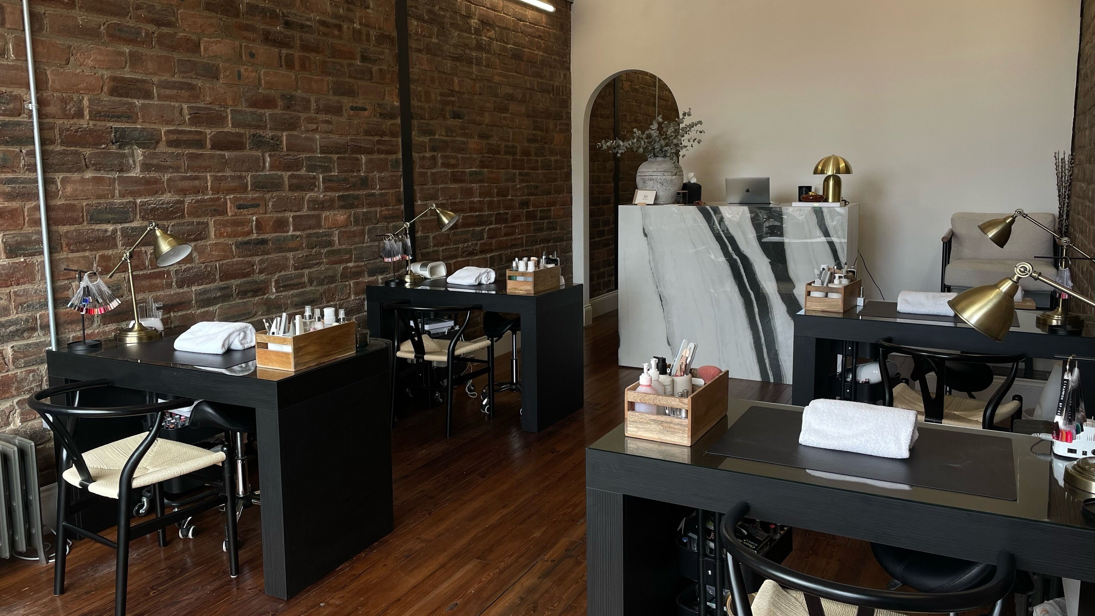 Modern beauty salon interior at Sò, Glasgow, Scotland, GB with stylish decor and manicure stations.
