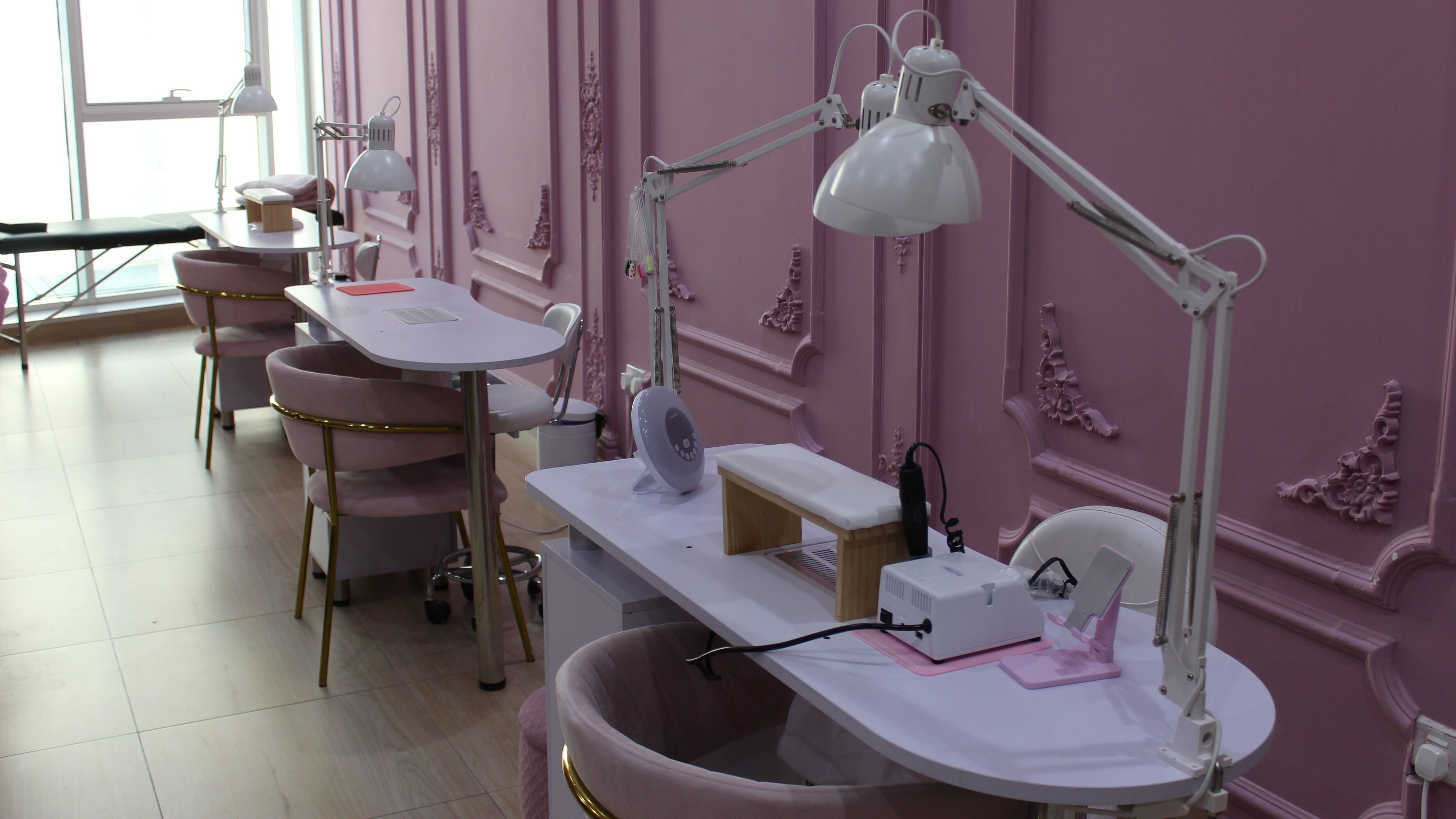 Elegant nail stations at Foxy Lane Russian Nail Salon, دبي, دبي, AE with pink decor and plush seating.
