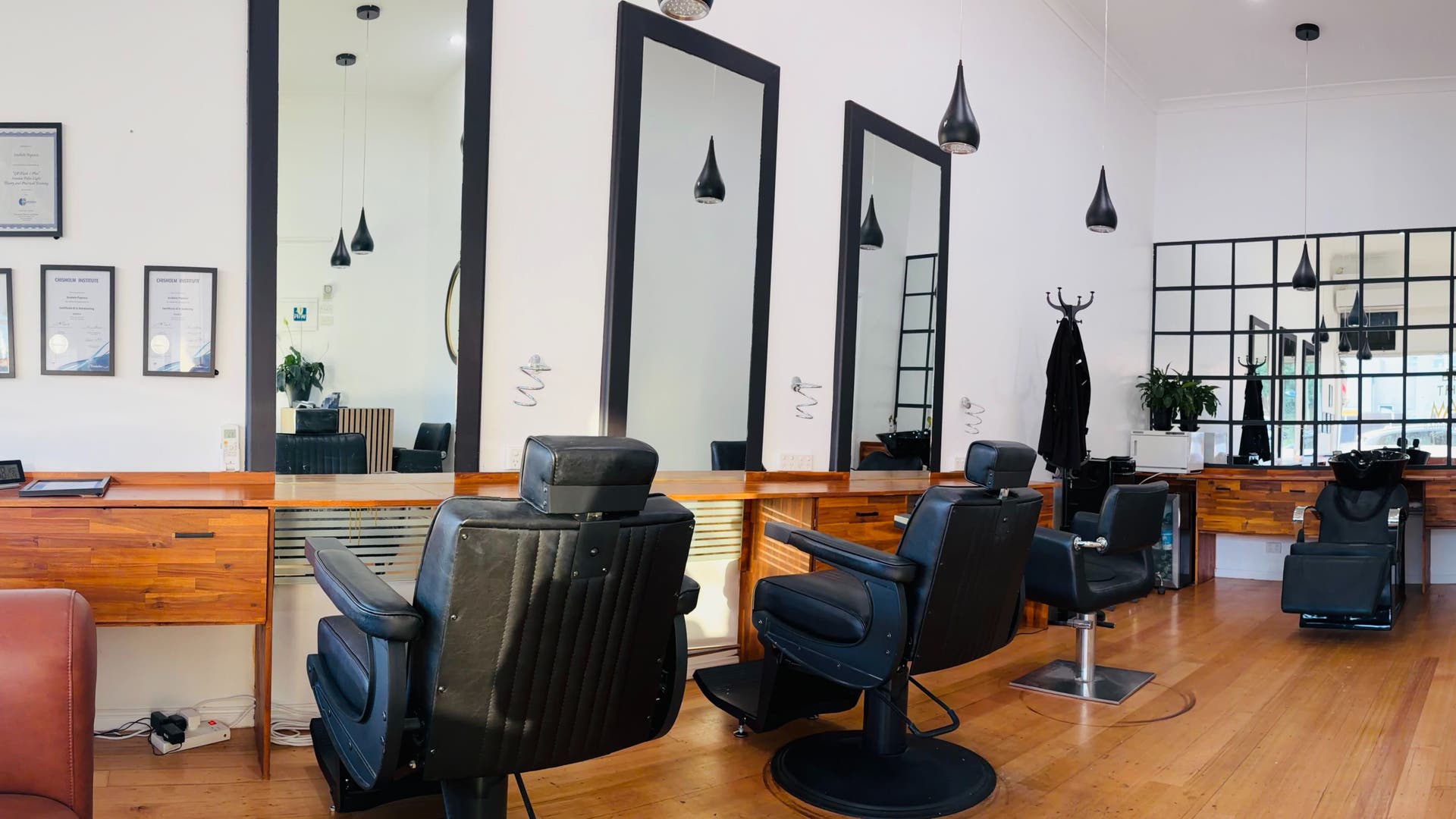 Modern interior of Be The Man Barber in Melbourne, Victoria, AU with leather chairs and wooden decor.
