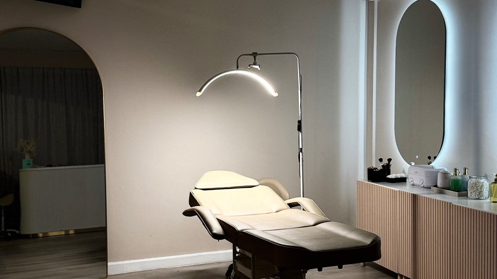 A cozy treatment room at The Lash Bar Boutique in Melbourne, Victoria, AU, features a stylish chair and ambient lighting.
