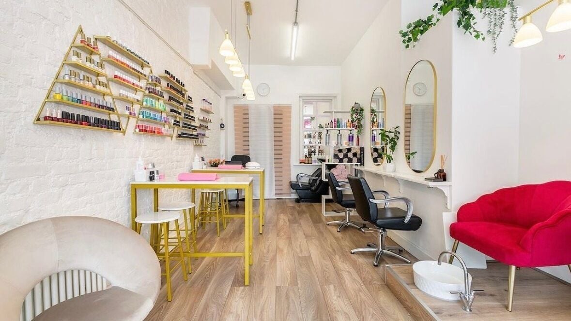 Modern interior of Arta Beauty Clinic in London, England, GB showcasing stylish chairs and nail polish display.