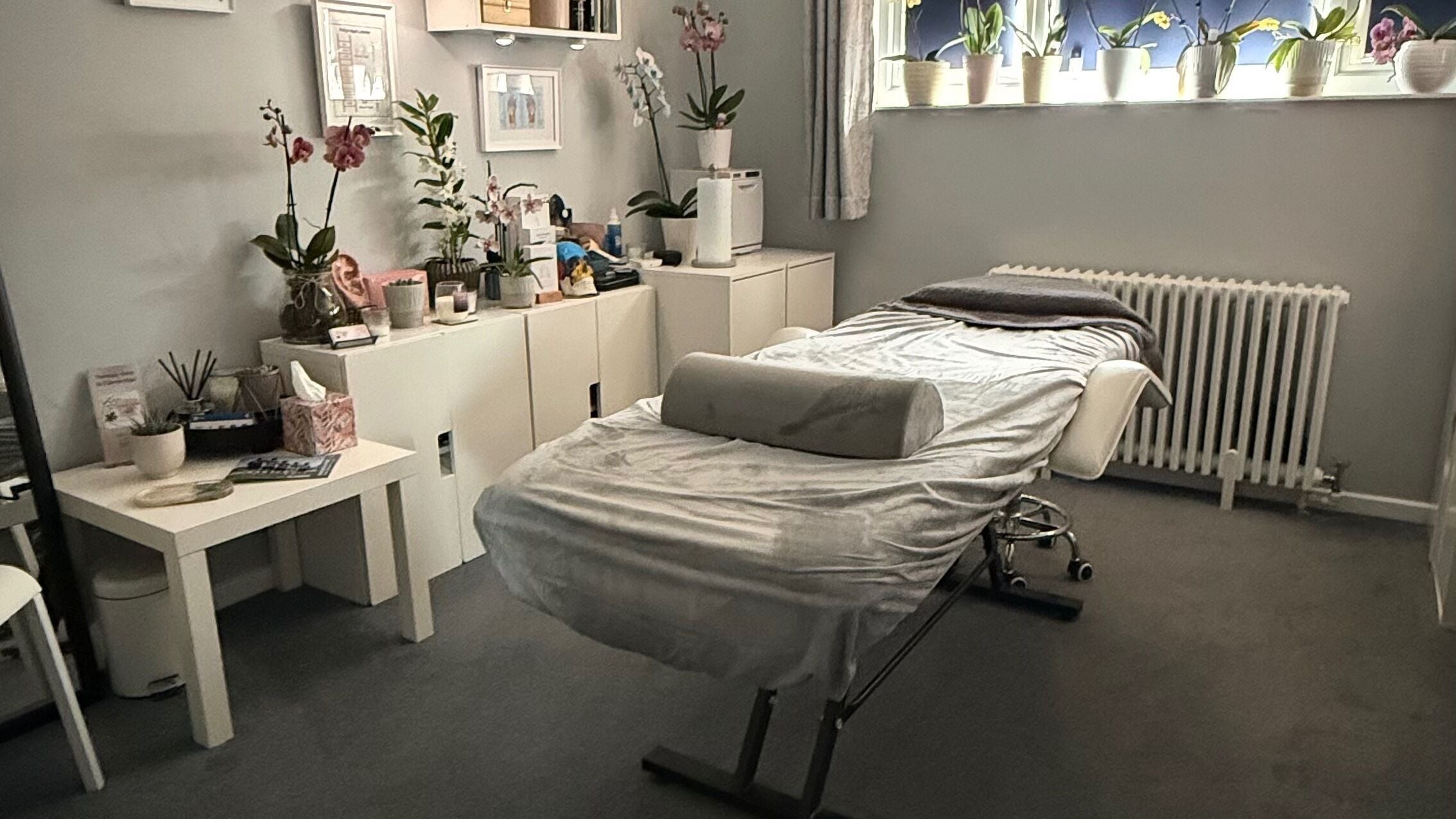 Blooming Orchid Room in Edenbridge, England, GB featuring a serene massage area with orchids and calming decor.