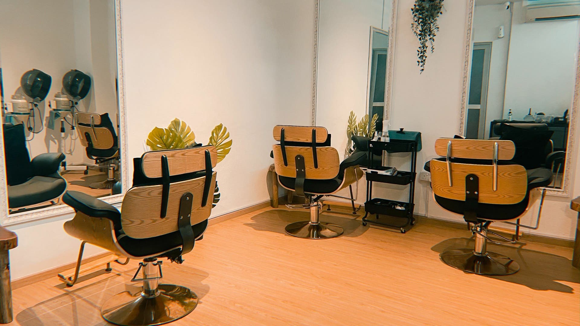 Chic beauty salon interior at Charmtress.Sg in Singapore, Singapore, SG with stylish wooden chairs and mirrors.