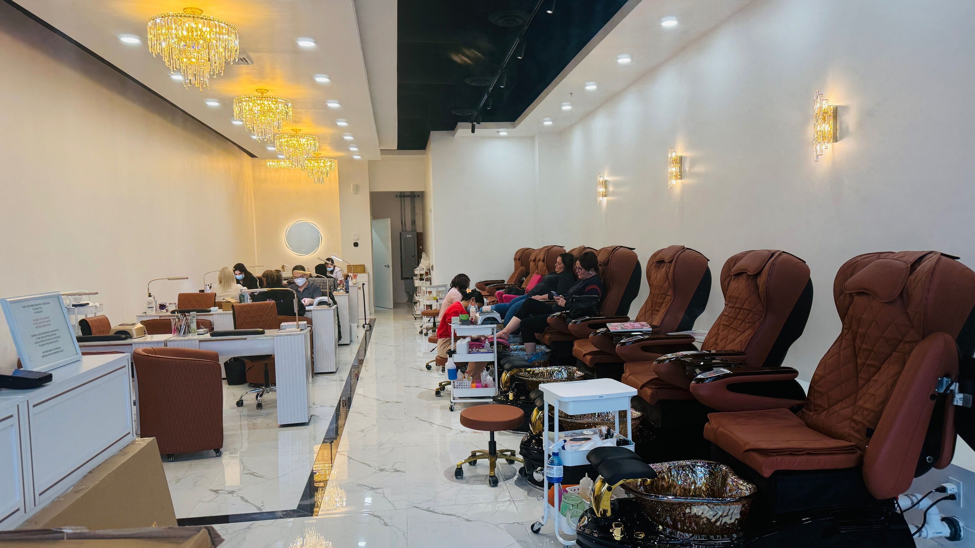 Foxie Nails Lounge in Pickerington, Ohio, US features plush pedicure chairs under elegant chandeliers.