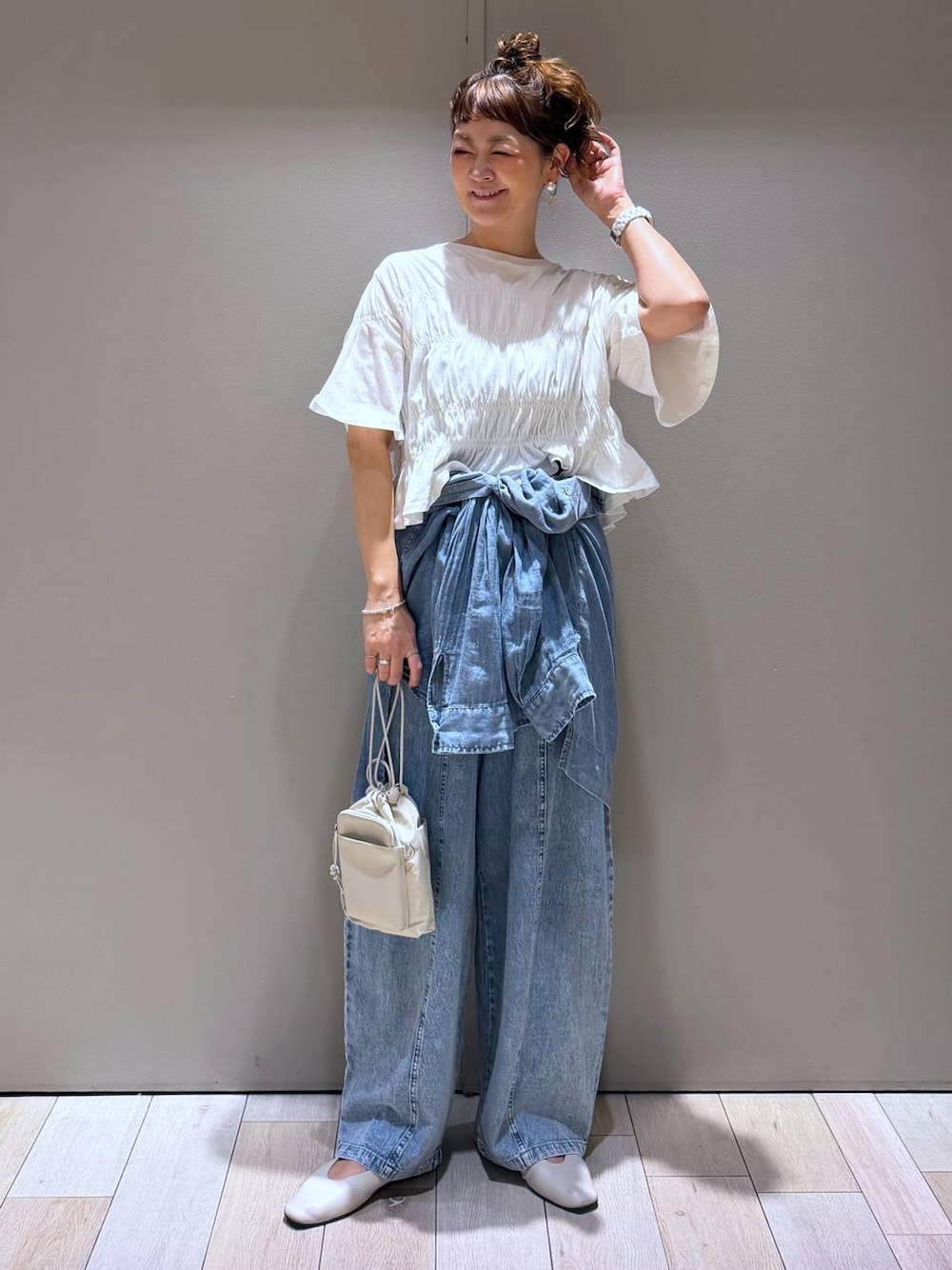 ホワイト系のパンプス、ブルー系のシャツ/ブラウス、ブルー系のデニムパンツを着用したレディースの春コーディネートの1枚目の写真
