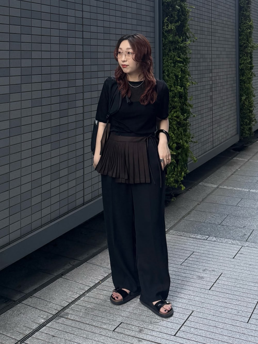 ブラック系のその他パンツ、ゴールド系のメガネ、ブラウン系のベルトを着用したレディースの春コーディネートの1枚目の写真