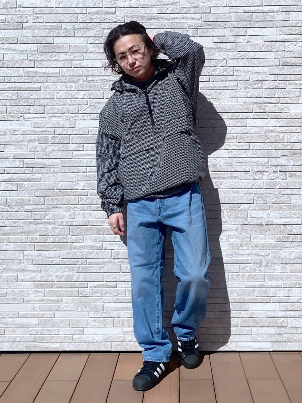 グレー系のスウェット、ブルー系のデニムパンツ、ブラック系のパーカーを着用したメンズの春コーディネートの1枚目の写真