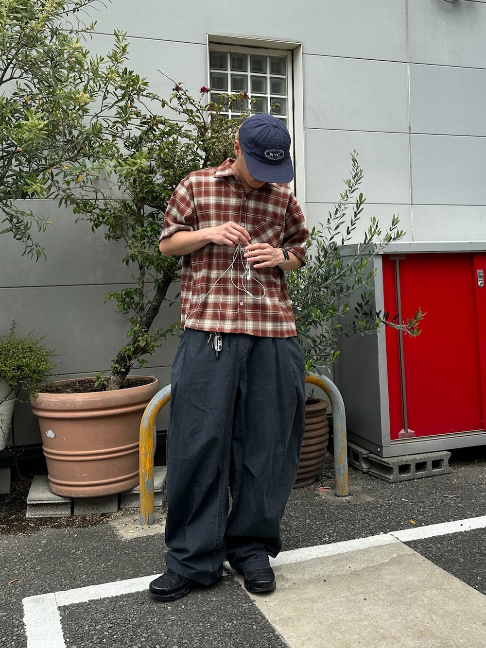ブラック系のスニーカー、ブラック系のパンツ、レッド系のシャツ/ブラウスを着用したメンズの春コーディネートの1枚目の写真