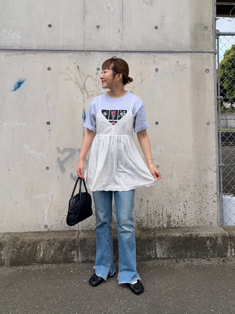 ブルー系のデニムパンツ、ホワイト系のシャツ/ブラウス、グレー系のTシャツ/カットソーを着用したレディースの春コーディネートの1枚目の写真