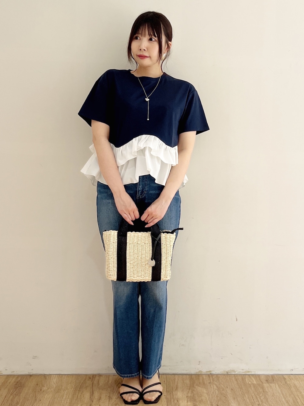 ブルー系のデニムパンツ、ブルー系のデニムパンツ、ブラック系のトートバッグを着用したレディースの春コーディネートの1枚目の写真