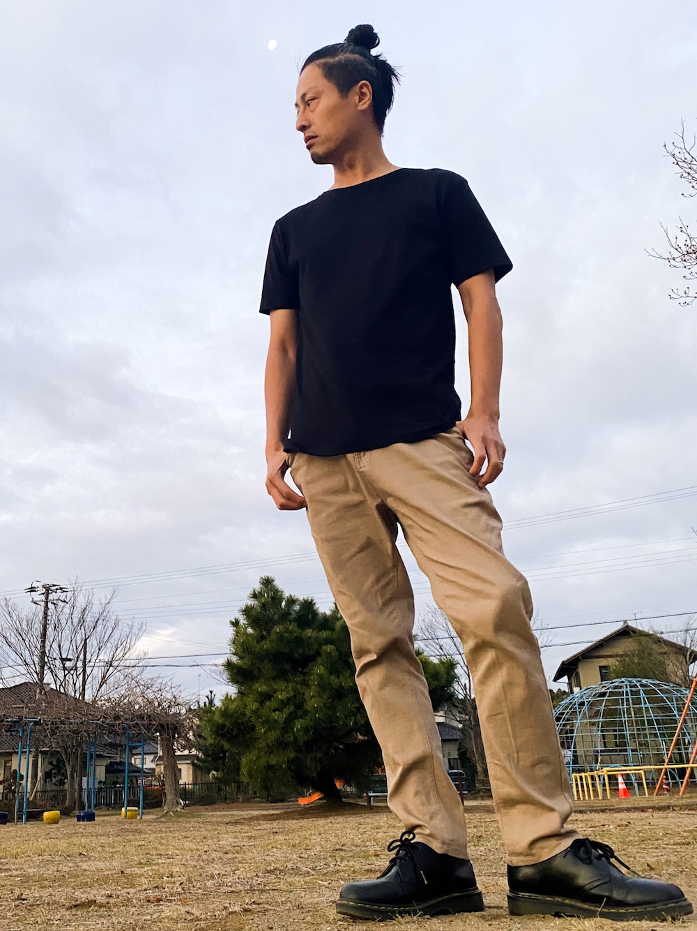 ブラック系のドレスシューズ、ベージュ系のその他パンツ、ホワイト系のTシャツ/カットソーを着用したメンズの冬コーディネートの1枚目の写真