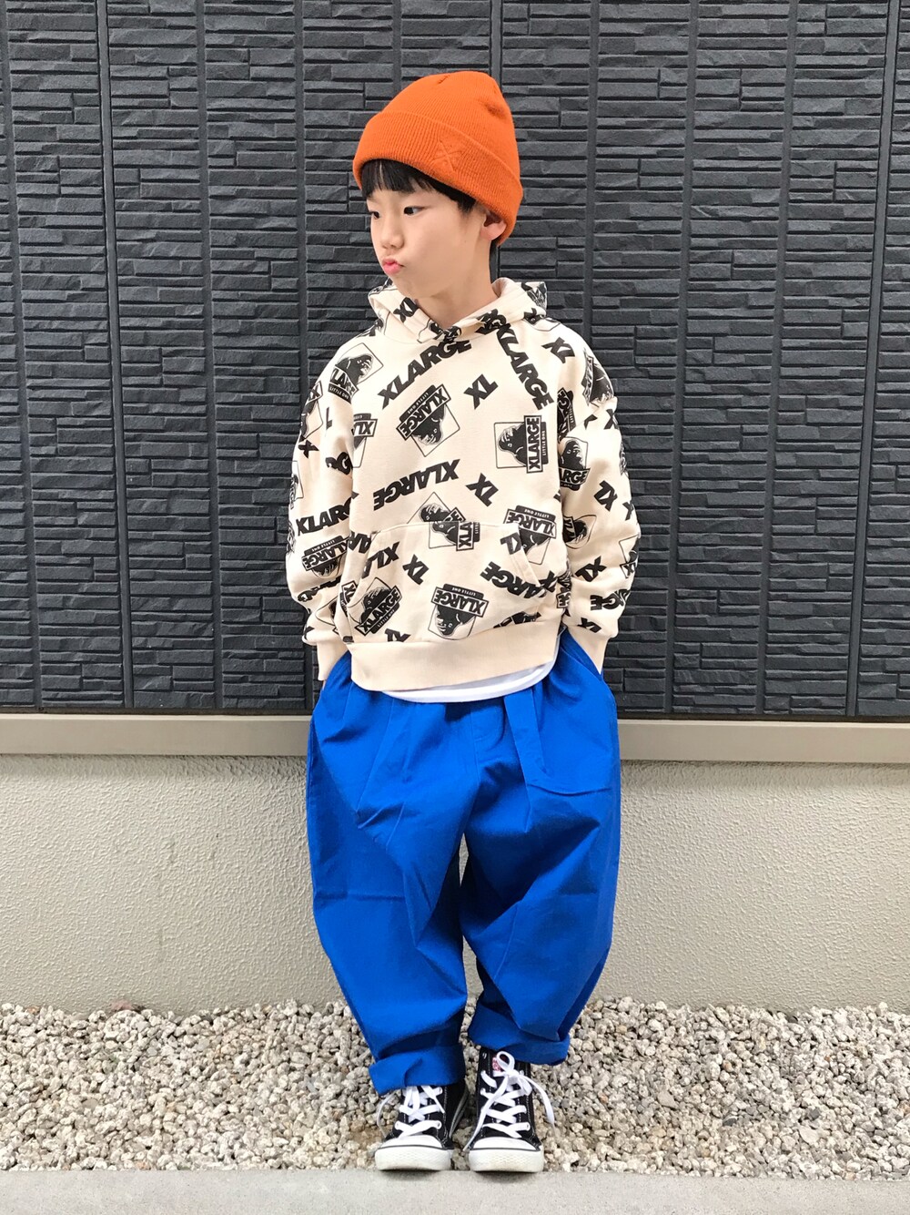 ホワイト系のパーカー、ブルー系のその他パンツ、オレンジ系のニットキャップ/ビーニーを着用したキッズの冬コーディネートの1枚目の写真
