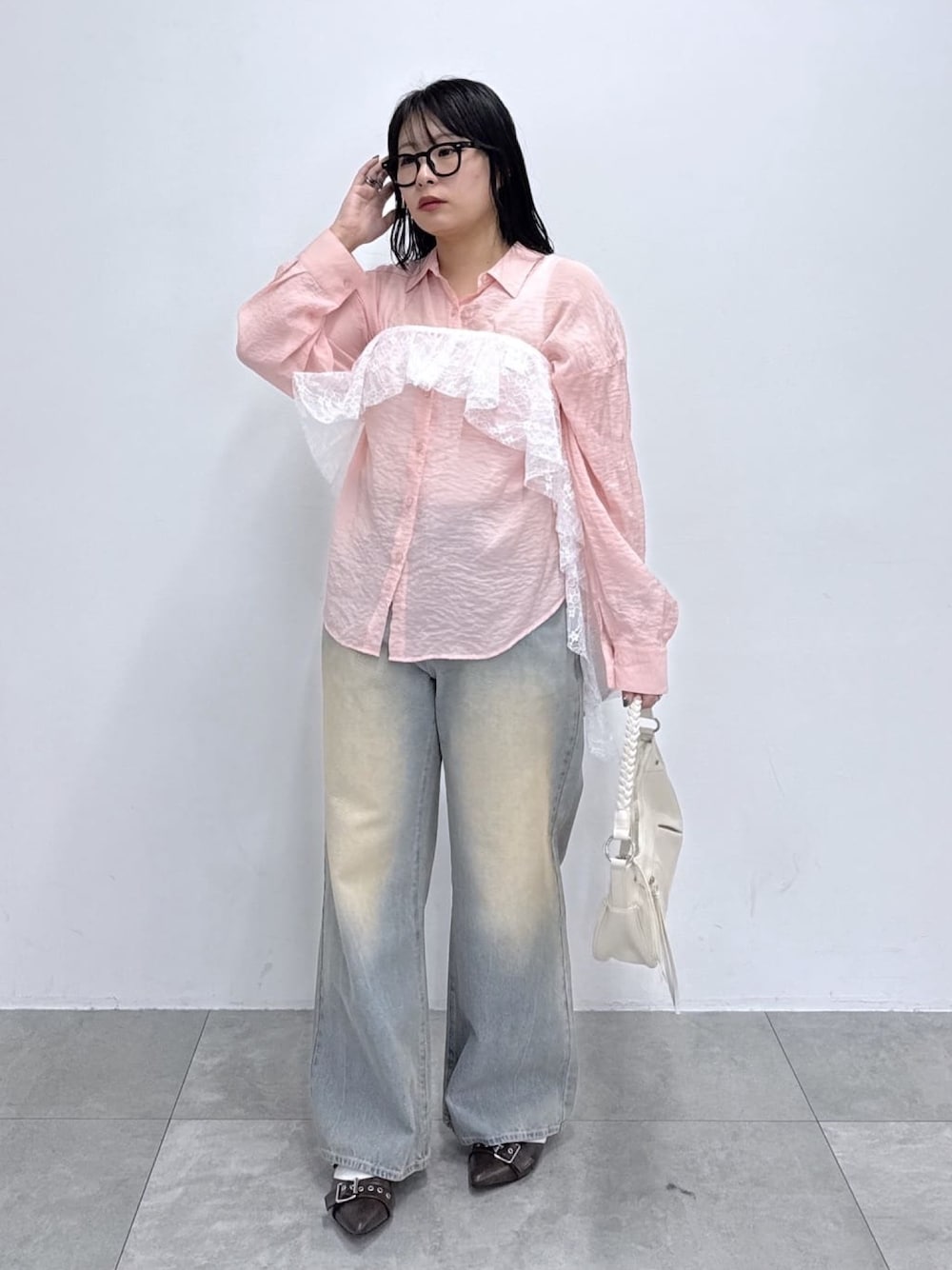 ピンク系のシャツ/ブラウス、ブルー系のデニムパンツ、ブラウン系のパンプスを着用したレディースの春コーディネートの1枚目の写真