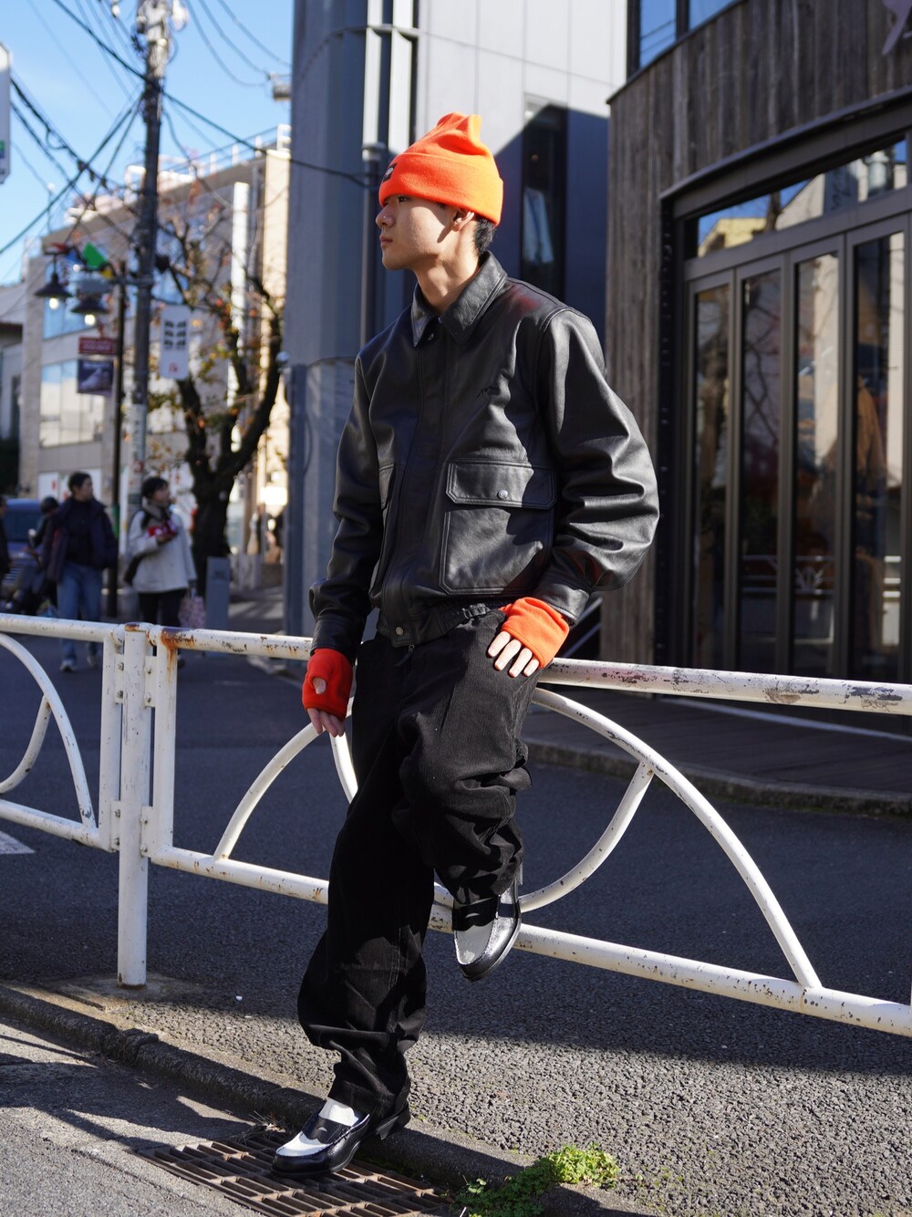ブラック系のブルゾン、ブラック系のその他パンツ、オレンジ系の手袋を着用したメンズの冬コーディネートの1枚目の写真