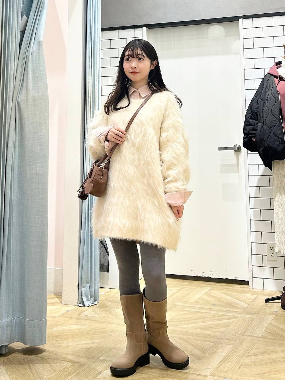 ブラウン系のボストンバッグ、ピンク系のシャツ/ブラウス、ベージュ系のブーツを着用したレディースの冬コーディネートの1枚目の写真