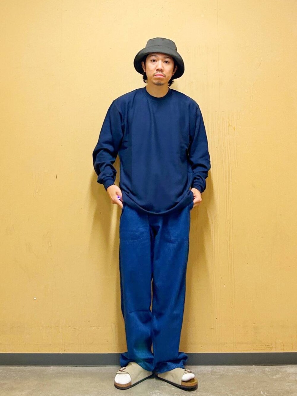 ベージュ系のサンダル、ブルー系のTシャツ/カットソー、ブルー系のデニムパンツを着用したメンズの夏コーディネートの1枚目の写真