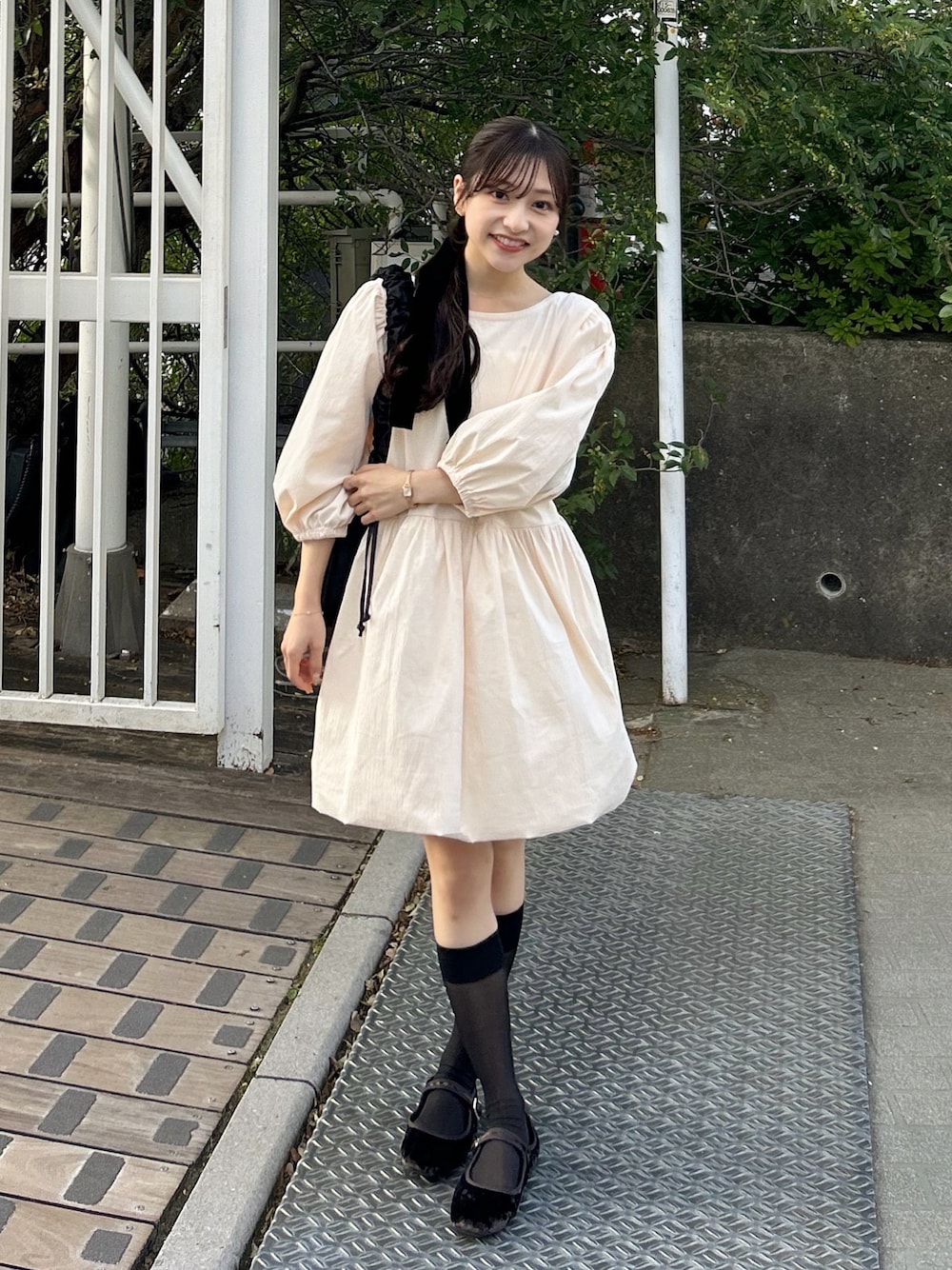 ブラウン系のパンプス、ホワイト系のチュニック、ブラック系のショルダーバッグを着用したレディースの秋コーディネートの1枚目の写真
