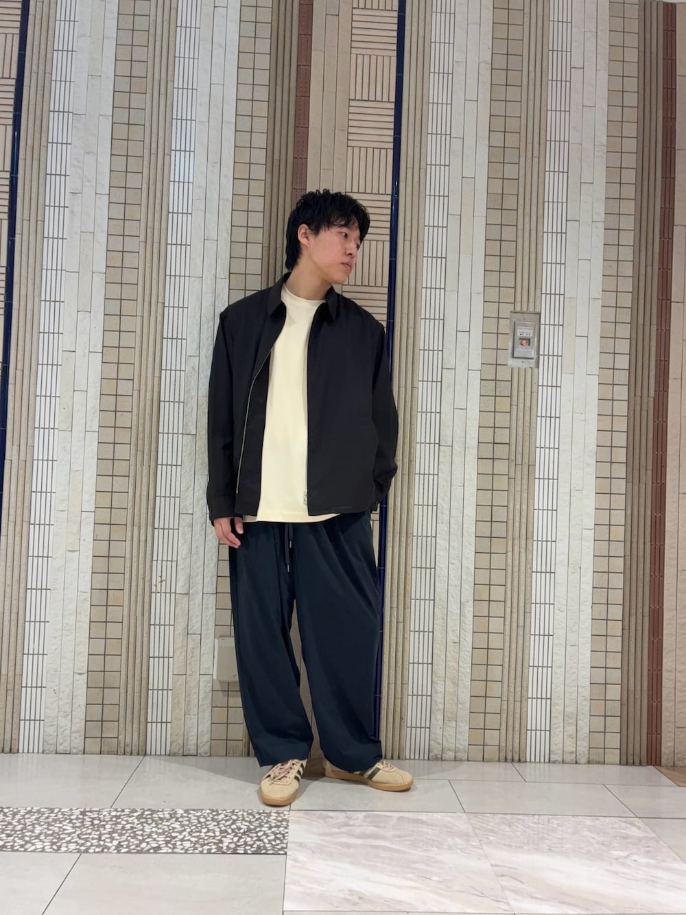 ブラック系のブルゾン、ベージュ系のスニーカー、ブルー系のその他パンツを着用したメンズの春コーディネートの1枚目の写真