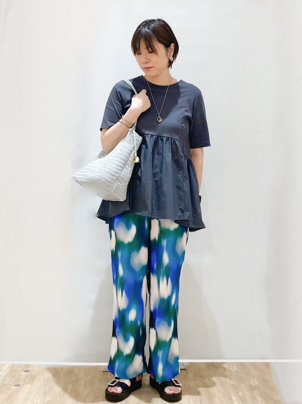 グレー系のTシャツ/カットソー、グレー系のトートバッグ、グリーン系のその他パンツを着用したレディースの春コーディネートの1枚目の写真