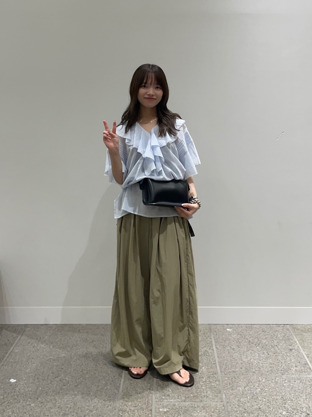 ブルー系のシャツ/ブラウス、ブラック系のボディバッグ/ウエストポーチ、ベージュ系のその他パンツを着用したレディースの夏コーディネートの1枚目の写真