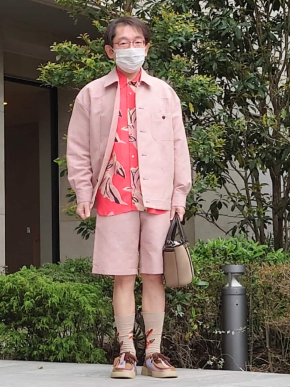 ブラウン系のトートバッグ、ピンク系のその他パンツ、ピンク系のブルゾンを着用したメンズの春コーディネートの1枚目の写真